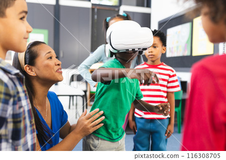 In school, diverse group of students exploring virtual reality with their teacher In school, diverse group of students exploring virtual reality with their teacher 116308705