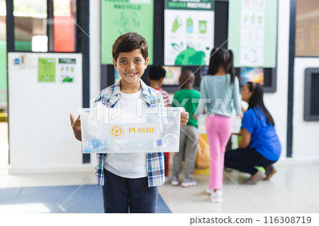 In school, diverse group of students and teacher in classroom focusing on recycling In school, diverse group of students and teacher in classroom focusing on recycling 116308719