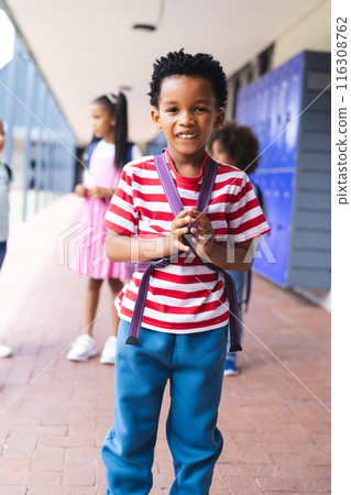 In school, young African American boy is standing, smiling outdoors 116308762