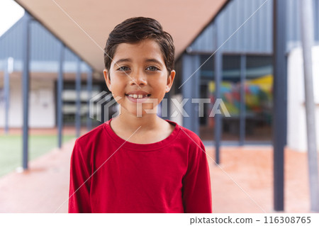 In school, biracial young boy with a bright smile standing outside 116308765