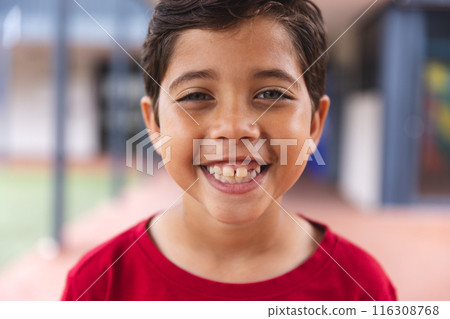 In school, young biracial male student wearing a red shirt is smiling outdoors 116308768