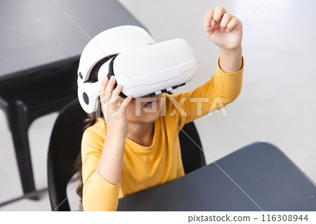 In school, young biracial female student wearing a VR headset in the classroom In school, young biracial female student wearing a VR headset in the classroom 116308944