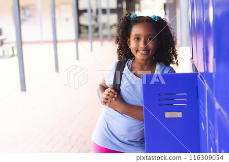Biracial girl stands by school lockers, with copy space 116309054