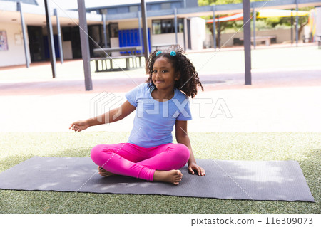 Biracial girl practices yoga at school, with copy space 116309073