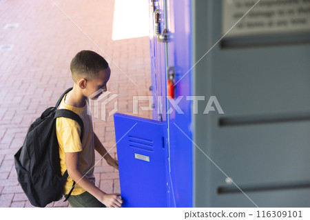 Biracial boy at school locker, with copy space 116309101