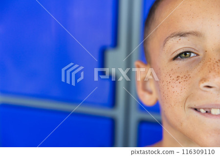 Close-up of a biracial boy smiling in school, with copy space 116309110