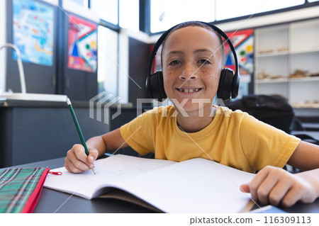 Biracial boy studies in a classroom at school Biracial boy studies in a classroom at school 116309113