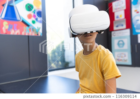 Biracial boy explores virtual reality in a classroom at school 116309114