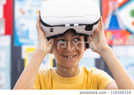 Biracial boy explores virtual reality in a classroom at school 116309119