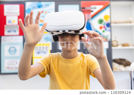 Biracial boy explores virtual reality in a classroom at school Biracial boy explores virtual reality in a classroom at school 116309124