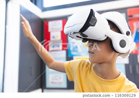 Biracial boy explores virtual reality in a school setting 116309129