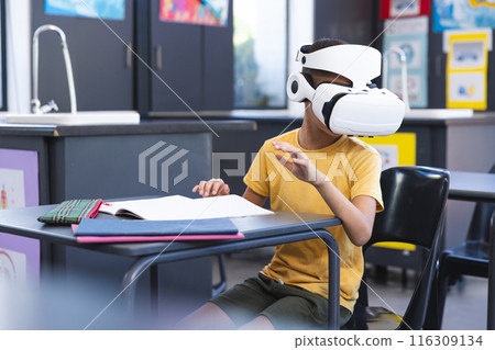 Biracial boy explores virtual reality in a classroom at school Biracial boy explores virtual reality in a classroom at school 116309134
