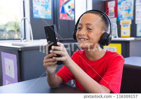 Biracial boy enjoys technology at school using a tablet 116309157