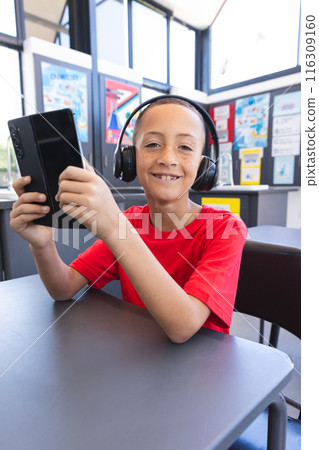 Biracial boy enjoys technology at school using a tablet 116309160