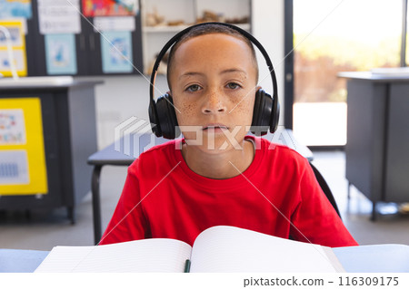 Biracial boy studies intently at school on a video call Biracial boy studies intently at school on a video call 116309175