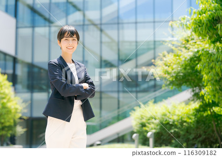 A woman in a suit standing in front of an office building 116309182