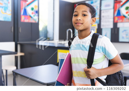 Biracial boy stands confidently in a classroom at school Biracial boy stands confidently in a classroom at school 116309202
