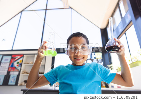 Biracial boy holds science beakers in a classroom 116309291