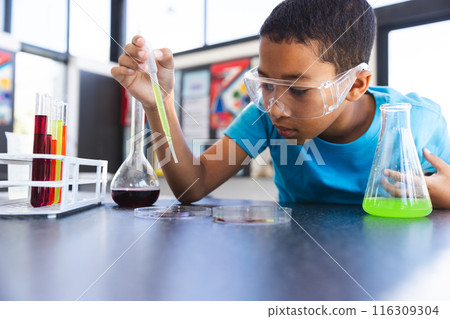 Biracial boy engages in a science experiment at school in the classroom Biracial boy engages in a science experiment at school in the classroom 116309304