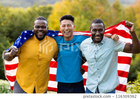 Portrait of happy diverse male friends covered with flag of usa in garden Portrait of happy diverse male friends covered with flag of usa in garden 116309362