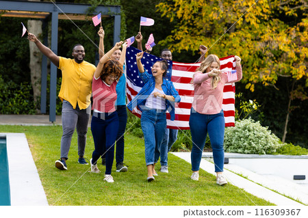 Happy diverse friends holding flags of usa and walking in garden 116309367