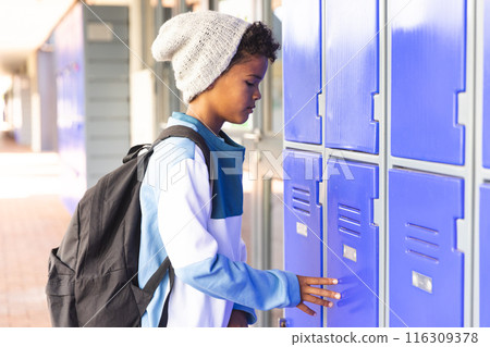 Biracial boy at school locker, with copy space 116309378
