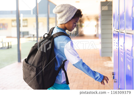 Biracial boy at school opens his locker Biracial boy at school opens his locker 116309379