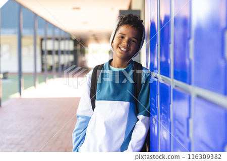 Biracial boy stands by school lockers, with copy space 116309382