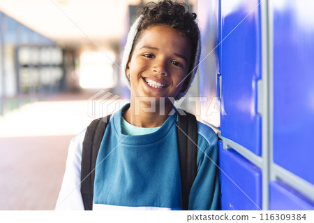 Biracial boy smiling at school, with copy space 116309384