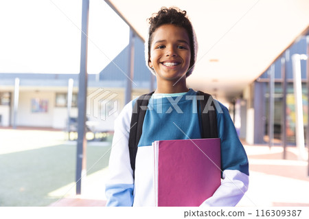 Biracial boy smiles at school, with copy space 116309387