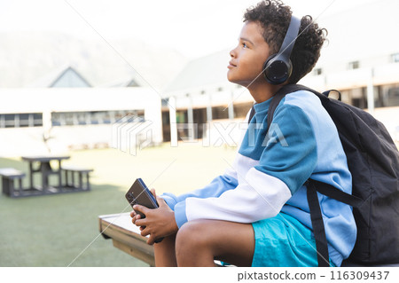Biracial boy enjoys music at school, with copy space 116309437