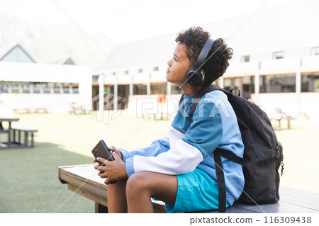 Biracial boy enjoys music at school, with copy space Biracial boy enjoys music at school, with copy space 116309438