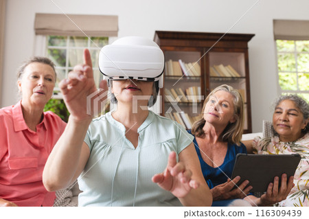 Diverse senior female friends exploring virtual reality at home 116309439