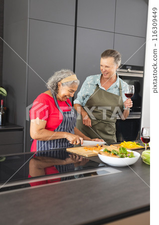 Diverse senior female friends cooking together at home Diverse senior female friends cooking together at home 116309449