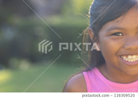 Outdoors, young biracial girl smiling brightly, wearing pink top, copy space Outdoors, young biracial girl smiling brightly, wearing pink top, copy space 116309520