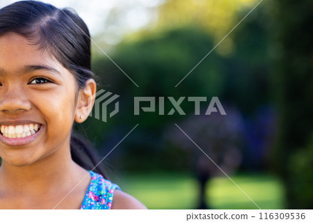 Outdoors, young biracial girl smiling brightly with colorful dress, copy space Outdoors, young biracial girl smiling brightly with colorful dress, copy space 116309536