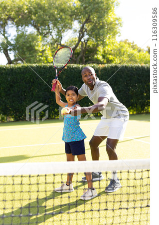 Outdoors, diverse father and daughter playing tennis on sunny day Outdoors, diverse father and daughter playing tennis on sunny day 116309586