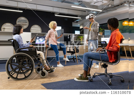 Business colleagues in office watching man using vr headset, asian woman in wheelchair, inclusivity Business colleagues in office watching man using vr headset, asian woman in wheelchair, inclusivity 116310078