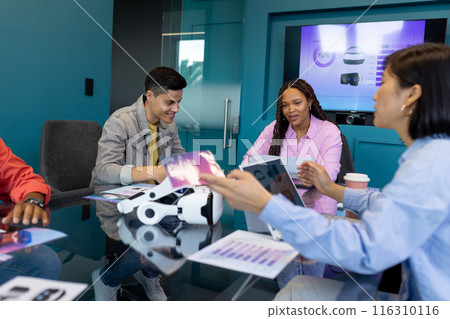 Colleagues from diverse backgrounds discuss VR tech in a modern business office 116310116