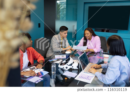 Diverse Business colleagues work together at a table with documents and a laptop during a meeting 116310119