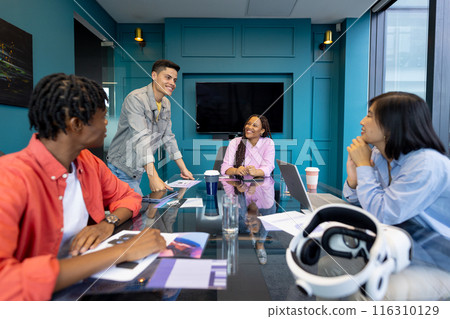 Diverse colleagues collaborate at a glass table on a startup project during their meeting 116310129