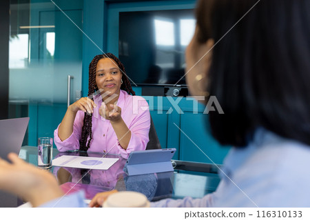 Two young biracial female colleagues discuss teamwork, business, and startup ideas 116310133