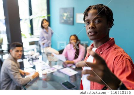 Diverse colleagues collaborating in modern office on startup business project Diverse colleagues collaborating in modern office on startup business project 116310156