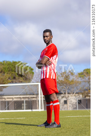 African American soccer player standing confidently on soccer field African American soccer player standing confidently on soccer field 116310173