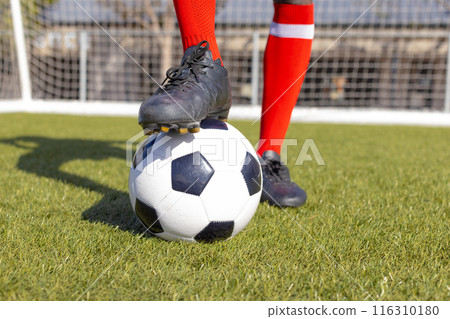 African American athlete training with soccer ball on a field African American athlete training with soccer ball on a field 116310180