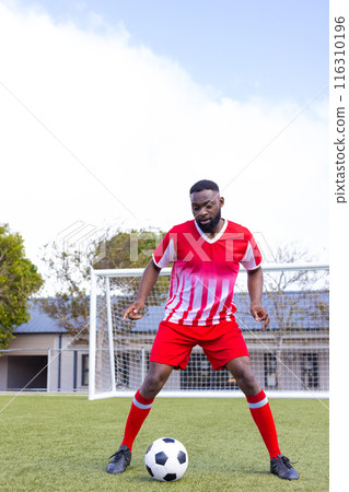 African american male athlete training with a soccer ball on the field, copy space African american male athlete training with a soccer ball on the field, copy space 116310196