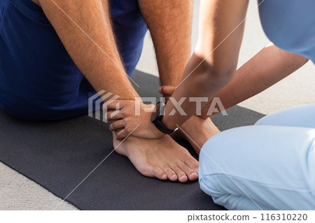 Diverse couple exercising together on yoga mat 116310220