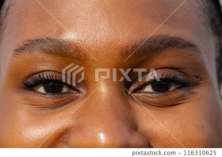 Close-up of person's face, smiling and looking at hydroponic farm in background Close-up of person's face, smiling and looking at hydroponic farm in background 116310625