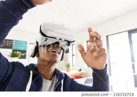 Using VR headset, African American male student experiencing virtual reality in classroom Using VR headset, African American male student experiencing virtual reality in classroom 116310729