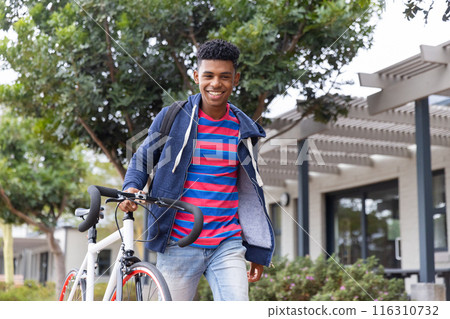 undefined walking with bicycle, smiling and enjoying outdoor campus environment 116310732